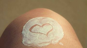 Lotion on knee with a heart drawing